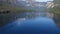 Flight above amazing Bohinj Lake in the morning. People are training in rowing. Blue deep water and Julian Alps mountains.