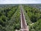 Flight above country railroad and rural platform station between villages, summer season