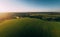 Flight above summer landscape: forest, green fields at countryside in hot air balloon or drone at sunset, aerial view