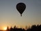 Flight in a balloon in the rays of the evening sunset. Hot air fills the sphere and raises it up. Adventure travel by air on an