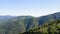 Flight from a canopy over a vast  rural mountain terrain