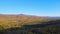 Flight on a drone over mountains covered with forest. Autumn. blue sky