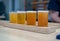 Flight of light colored craft beers sitting on wooden plank on a