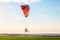 Flight on a motor glider in the blue sky with bright backlight sunlight over the green plain