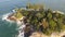 flight over beautiful tropical island. Waves crashing on rocks, sea green, on a sunny day.