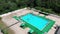 Flight over the blue pool with people on vacation. Aerial view on clean swimming pool