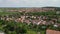 Flight over bohemian countryside with traditional village and red roofs. Aerial view