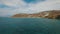 Flight over crystal water of the Aegean Sea towards coastline and mountains