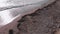 Flight over dirt beach with debris and plastic garbage after powerful strong storm. Endless plastic pollution of sea shore on beac