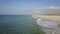 Flight over almost empty beach where the sea kisses the shore