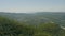 Flight over the green hills. Aerial video filming from a drone. Valley in the fog in the background. Landscape.