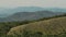 Flight over the green hills. Aerial video filming from a drone. Valley in the fog in the background. Landscape.