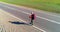 Flight over hitchhiker tourist walking on asphalt road. Huge rural valley at summer day. Backpack hiking guy.