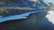 Flight over the Katun river covered with ice and snow with an automobile bridge over which transport travels in the Altai