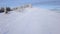 Flight over the lonely tourist girl walking along the top of a mountain covered with snow. Clear frosty weather