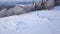 Flight over the lonely tourist girl walking along the top of a mountain covered with snow. Clear frosty weather