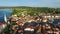 Flight over old city Piran, aerial panoramic view with old roofs, St. George\'s Parish Church, Tartini Square, and the sea.