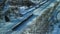 Flight over the railroad. A train runs along the rails. Winter industrial landscape. Aerial photography