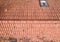 Flight over the red roof of a single family house with a chimney and a satellite antenna for inspection, control and preparation f