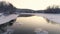 Flight over the river at sunset. Trees and mountains on the horizon are reflected in the water like in a mirror. Village