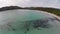 Flight over sea bay with surfers in France, Corsica, Santa Giulia beach. Aerial view.