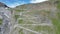 Flight over serpentine road towards summit of Stelvio Pass and mountain alps panorama, Italy