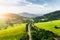 Flight over the summer mountains with mountain road serpentine