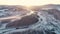 Flight over the winter river in the mountains. Beautiful sunrise from behind the mountains. Fog over the river. Snowy