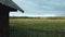 Flight past an old barn, over a wooden fence. Along a grassy meadow. At a low altitude. Aerial photography