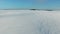 Flight and takeoff above snow fields in winter, aerial panoramic view. Snow pattern and texture.