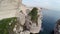 Flight and takeoff over Bonifacio bay area at sunset colors. Rocks and sea. Corsica, France. Aerial view.