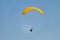 Flight on a yellow paraglider in blue sky
