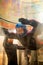 The flight of a young woman in blue helmet in a wind tunnel. Skydiving training.