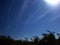 FLIMSY STREAKY CLOUD WISPS IN A BLUE SKY WITH SUN