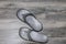 Flip Flop time - a pair of grey orthopedic flip flops - slightly worn and dirty sitting on a grey wooden plank floor - top view