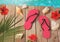 Flip flops and hibiscus flowers on wooden background. Summer holiday vacation concept. View from above