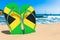 Flip flops with Jamaican flag on the beach. Jamaica   resorts, vacation, tours, travel packages concept. 3D rendering