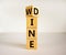 Fliped a wooden cube and changed the inscription `wine` to `dine` or vice versa. Beautiful white background, copy space