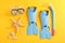 Flippers, snorkel, diving mask and starfishes on yellow background