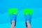 Flippers in water. Diver fins. Underwater kids legs in fins in swimming pool, top view. Mockup with copy space