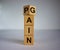 Flipping wooden cubes for change wording between pain to gain. Mindset for career growth business