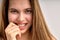 flirtatious girl with natural long brown hair looking at camera and smiling, close-up