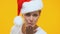 Flirty lady in Santa Claus hat sending air kiss to camera, holiday entertainment