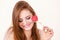 Flirty woman holding red wooden heart on stick