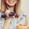 Flirty woman holding sunglasses and grapefruit