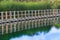 Floating boardwalk against green cattails reflected on still waters