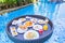 Floating breakfast set in tray with fried egg omelette sausage ham bread fruit milk juice coffee