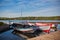 Floating Color Wooden Boat with Paddles and Its Reflection in a