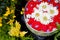 Floating colorful decorative flowers in an aluminum bowl of water