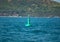 Floating green navigational buoy on blue sea. Marine signal buoy. Navigational Buoy marking a shipping channel